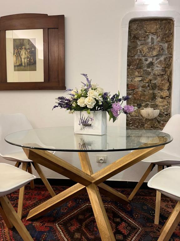 - une table en verre avec des fleurs dans la salle à manger dans l'établissement Golfo Dei Poeti Apartment, à Lerici