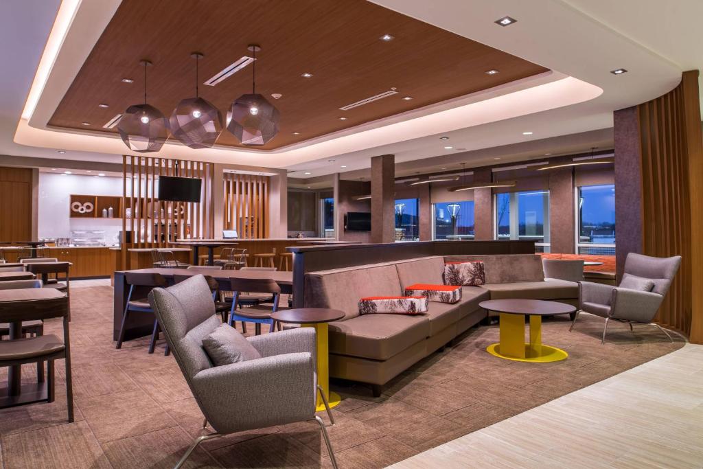 a hotel lobby with couches and tables and a bar at SpringHill Suites by Marriott Greensboro Airport in Friendship