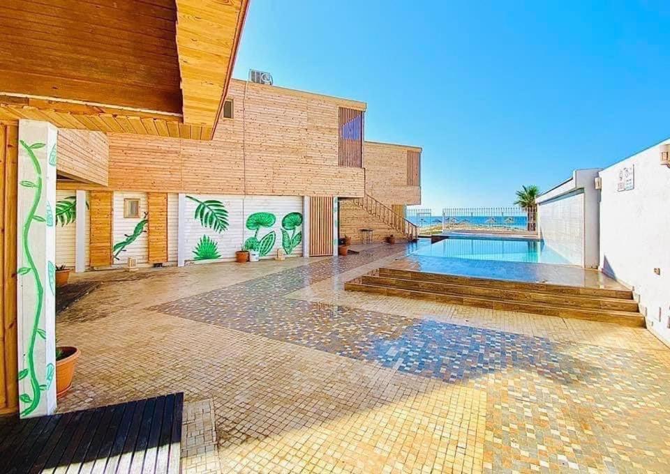 una casa con piscina y un edificio en Kélibia beach chalets, en Kelibia