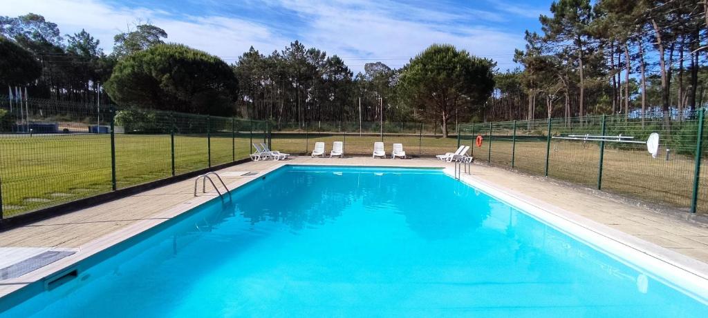 a swimming pool with chairs and a fence at HI Ovar - Pousada de Juventude in Ovar