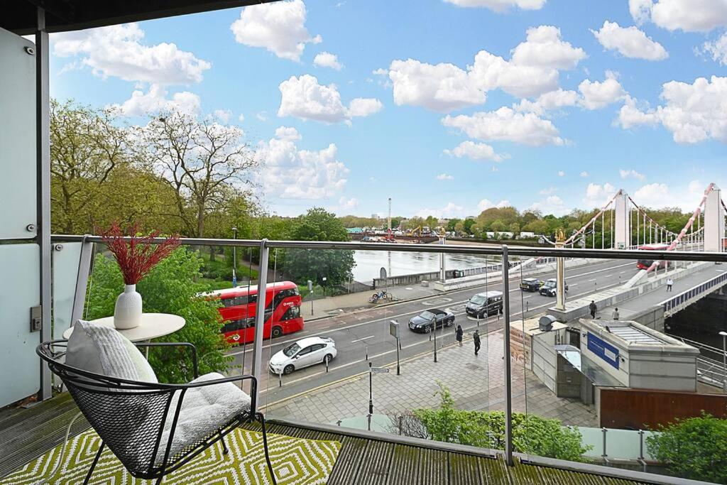 a balcony with a chair and a bridge over a highway at Queen Chelsea 77 in London