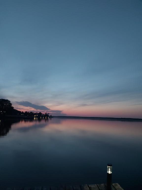 Una vista de un lago al atardecer con el cielo en Pokoje i apartamenty MatDar en Mikołajki