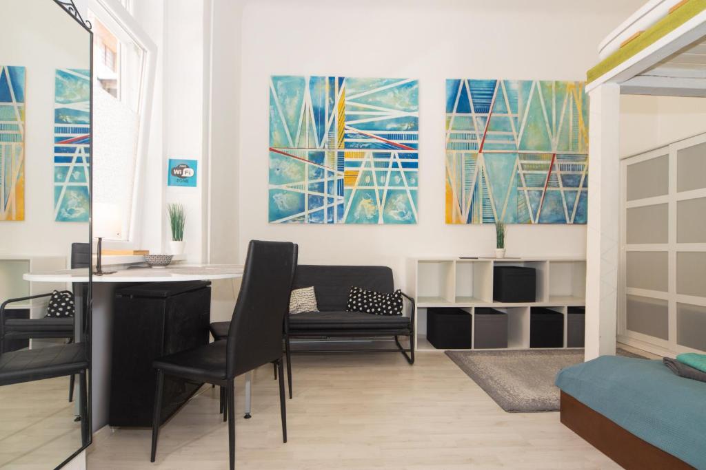ブダペストにあるCosy studio apartment with AirConditionerのリビングルーム(テーブル、椅子、絵画付)