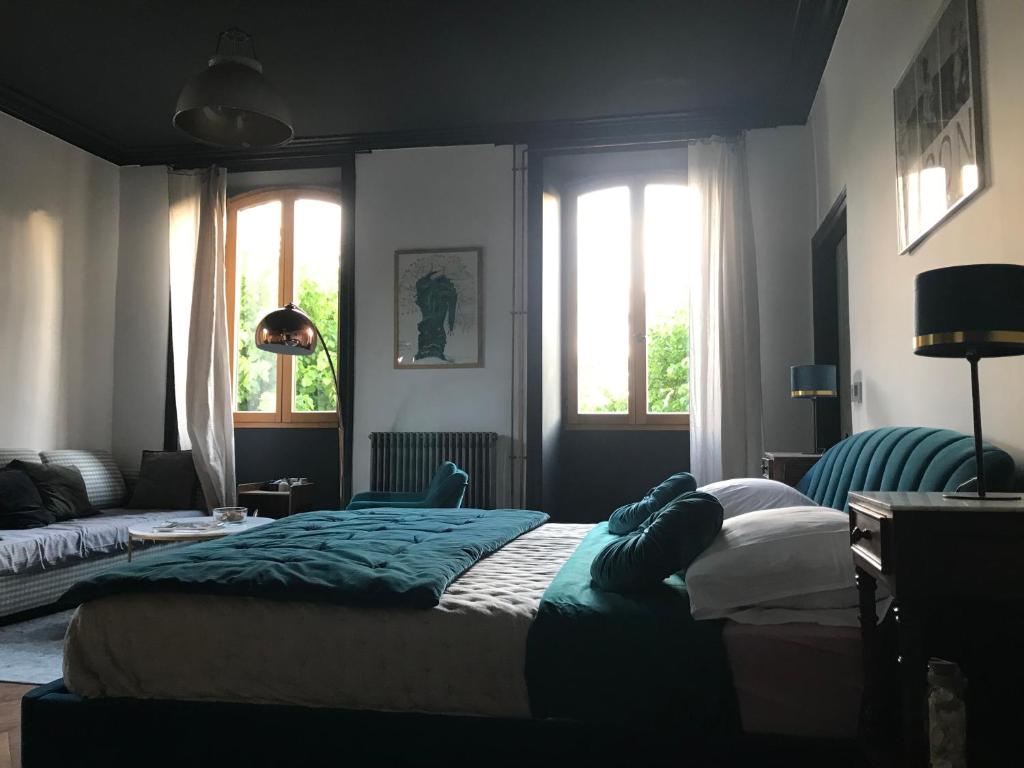 a bedroom with two beds and a couch and windows at Château de Bataillé in Figeac