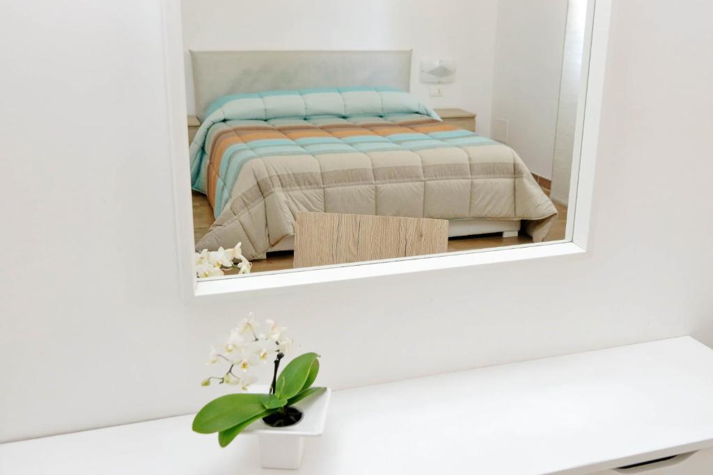 a mirror in a white room with a bed at B&B Felicioni in Fiumicino
