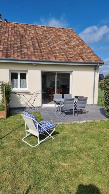 une maison avec un patio avec des chaises et une table dans l'établissement Maison au cœur de la Côte D'Opale, à Bellebrune
