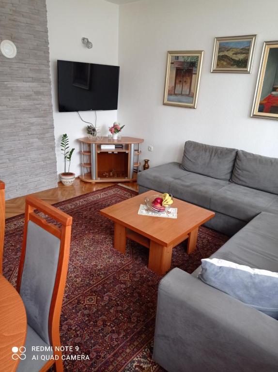 een woonkamer met een bank en een salontafel bij Apartman Asja in Visoko