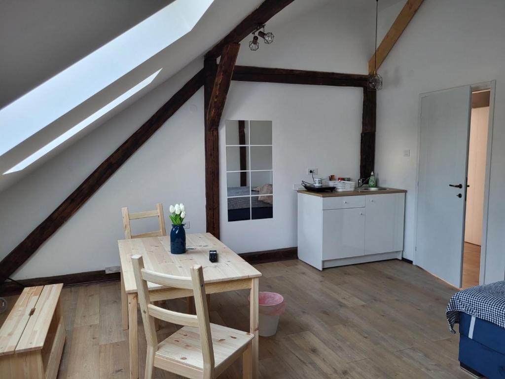 a room with a wooden table and a kitchen at Apartment By the River in Niš