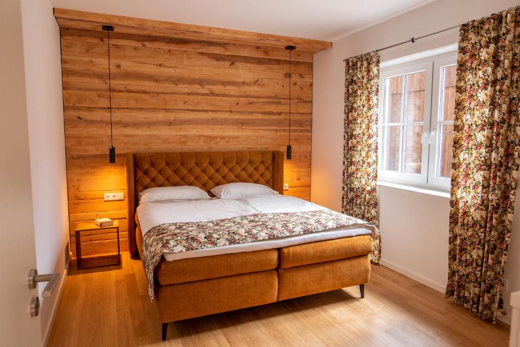 a bedroom with a bed and a wooden wall at Vierseitenhof Appartements in Burg