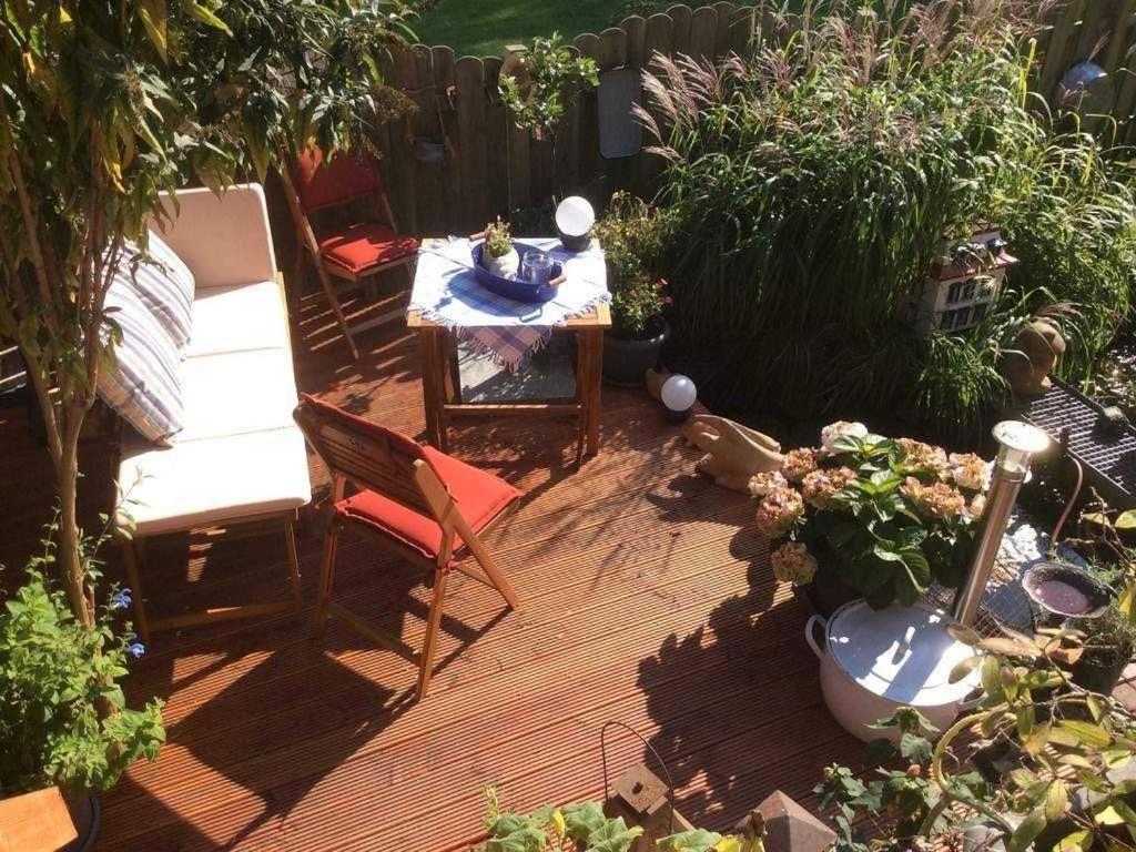 d'une terrasse avec une table et des chaises dans le jardin. dans l'établissement Schwalbennest_ Silke Felix, à Sierksdorf