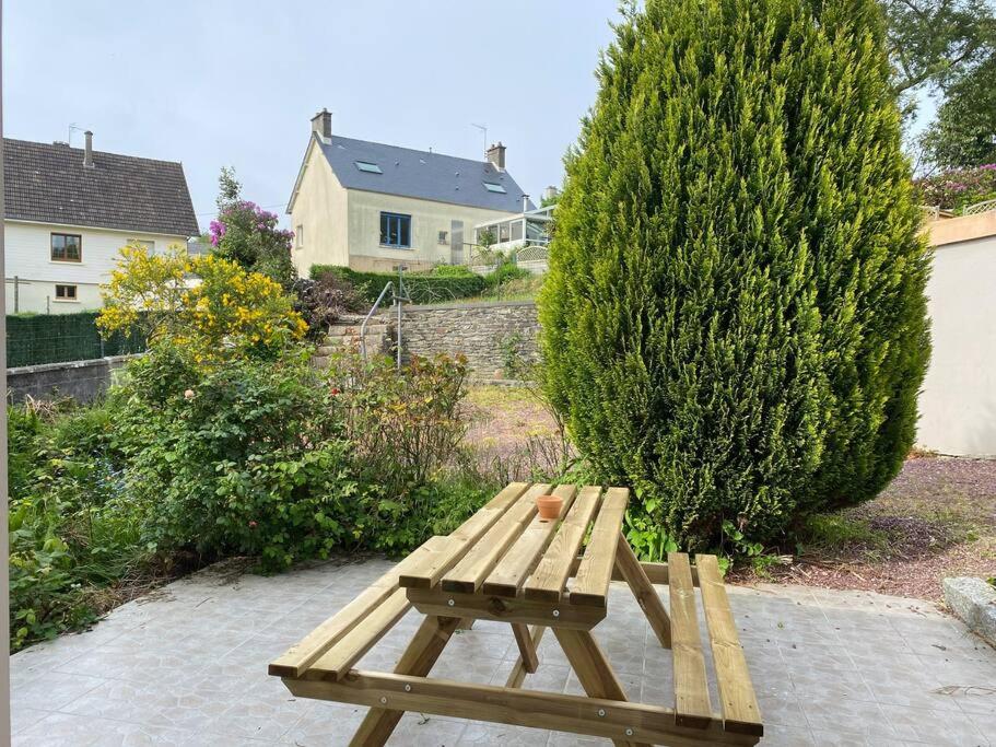 a wooden picnic bench sitting on a brick patio at Maison Village de La Verrerie in Cherbourg en Cotentin