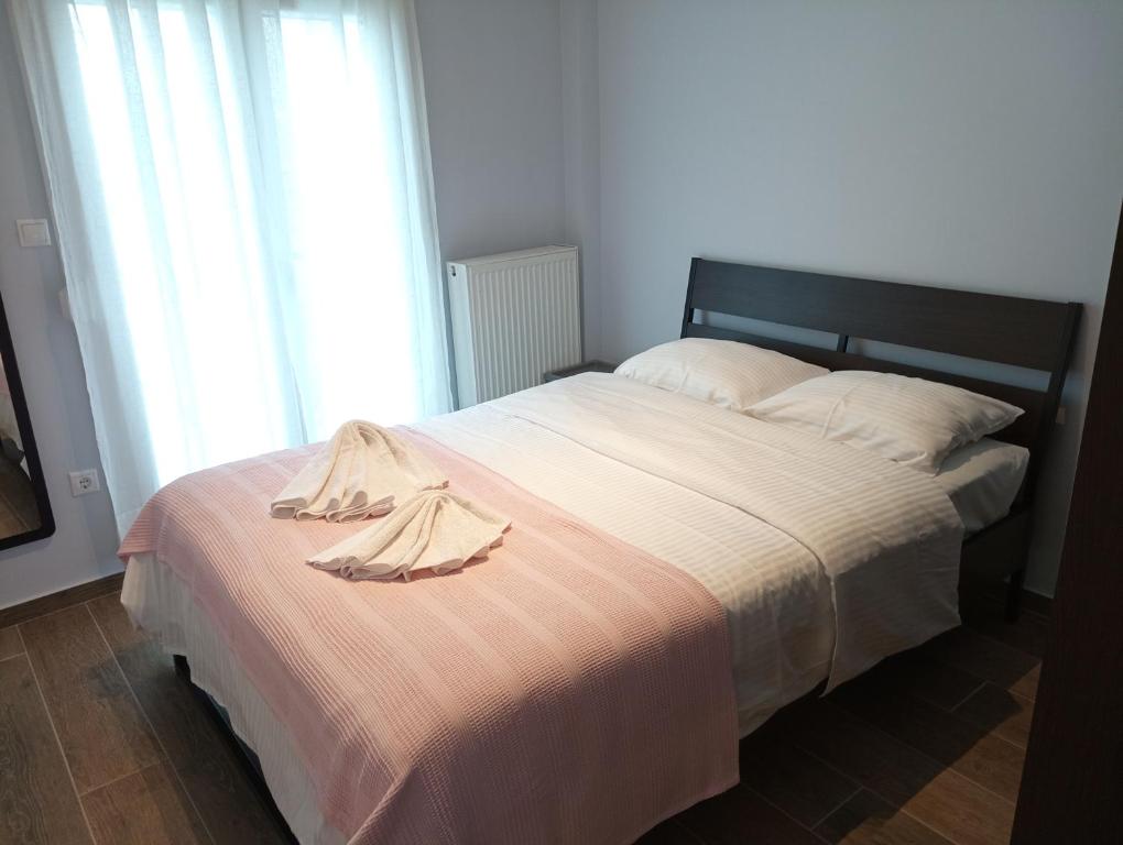 sypialnia z łóżkiem ze szlafrokiem w obiekcie Kalamaria brand new 1 bedroom apartment w Salonikach