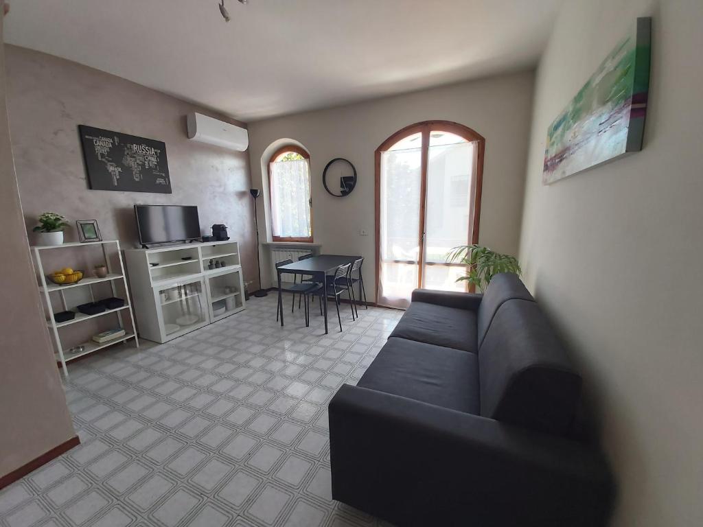 uma sala de estar com um sofá e uma mesa em I Limoni Bilocale in residence con piscina em Peschiera del Garda
