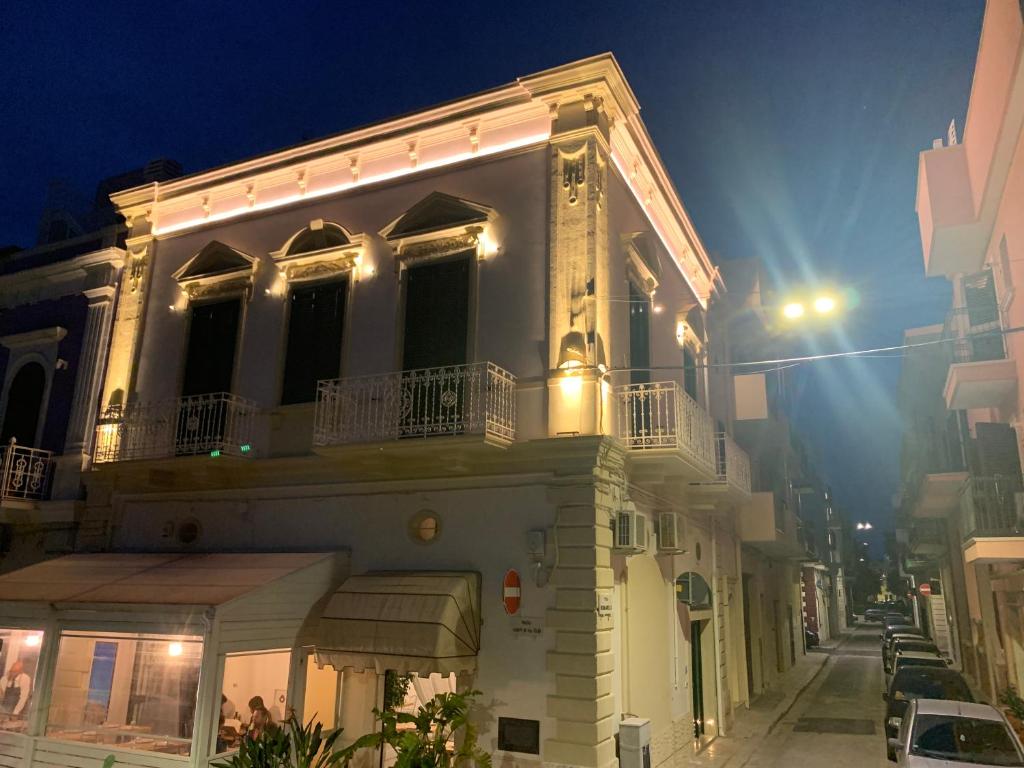 a white building with a balcony on a street at night at Il Sogno di Mimì in Polignano a Mare