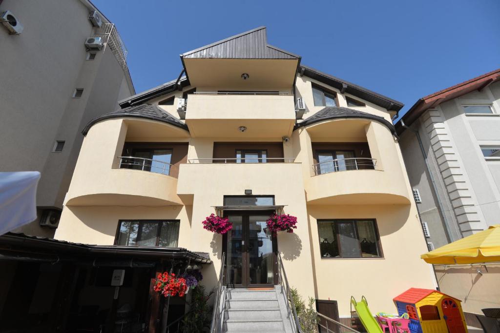 Um edifício com flores cor-de-rosa à frente. em Casa Octaral em Eforie Nord