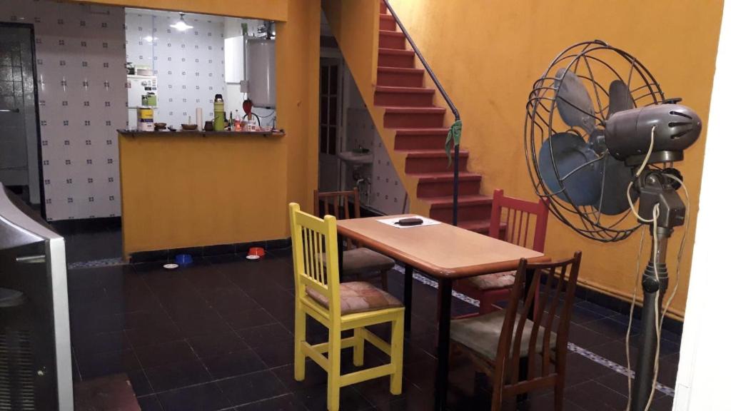 una mesa y sillas en una habitación con escalera en Bienvenidos al Sur en Buenos Aires