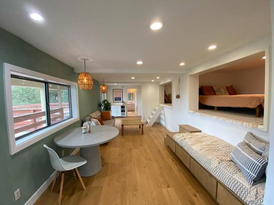 a living room with a couch and a table and a bed at Modern Apartment w/ Private Deck & BEAUTIFUL VIEWS in Topanga