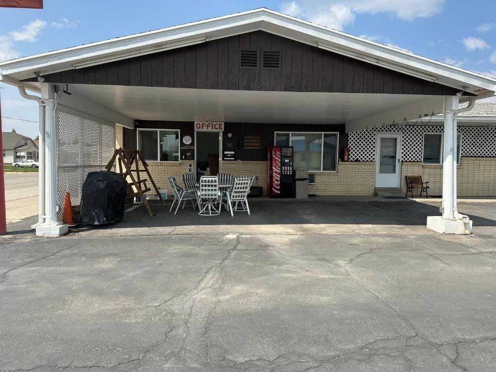 a building with chairs and tables in front of it at Fossil Butte Motel in Kemmerer