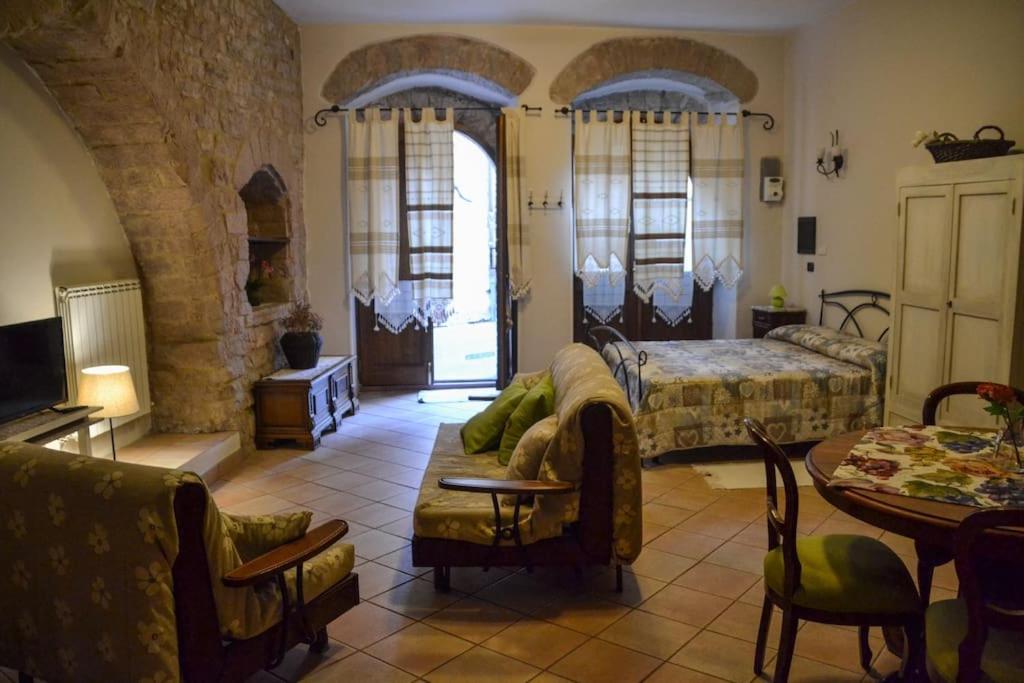 ein Wohnzimmer mit einem Bett, einem Tisch und Stühlen in der Unterkunft La Chiocciola Assisi in Assisi