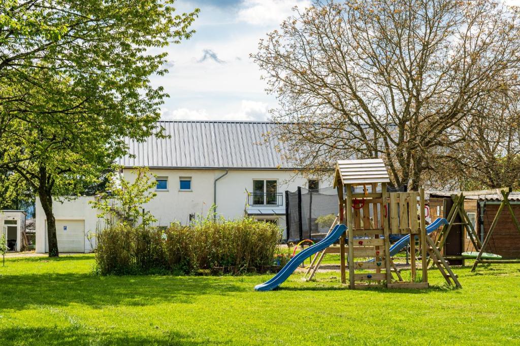 un parque infantil con un tobogán en un patio en Eifel-Apartments Orsfeld, en Orsfeld
