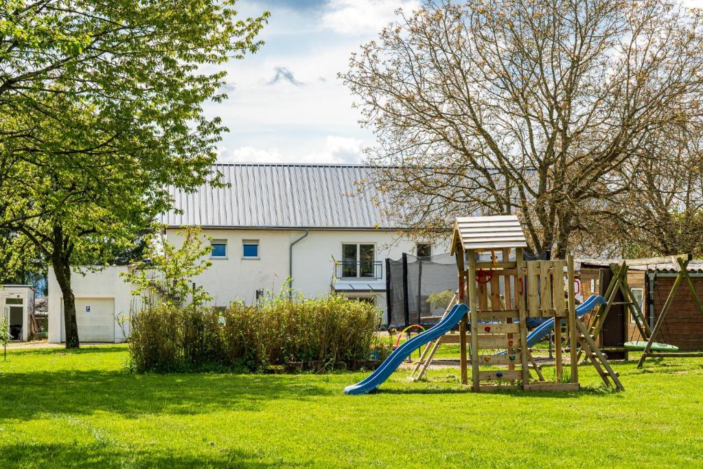 a playground with a slide in a yard at Eifel-Apartments Orsfeld in Orsfeld