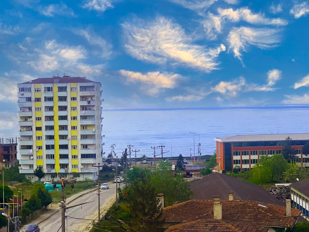 un grand bâtiment jaune en face de l'océan dans l'établissement Seabird Suite Apart Hotel, à Trabzon