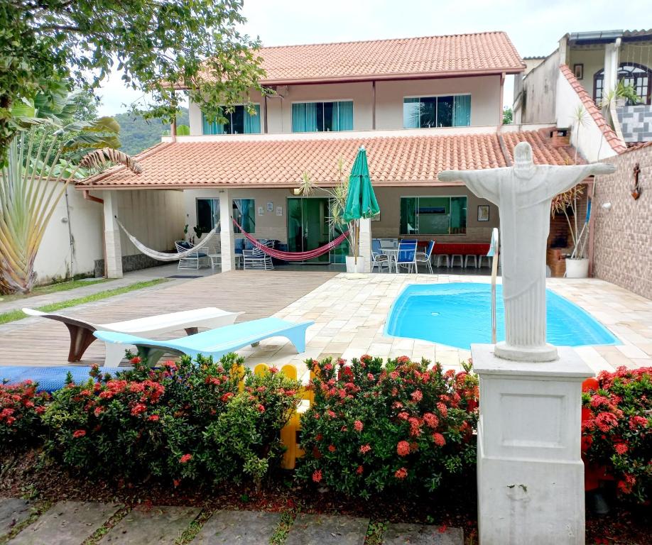 uma villa com piscina e um Cristo a estátua redentora em Linda casa com piscina aquecida e ar condicionado a 1h do RJ em Guapimirim
