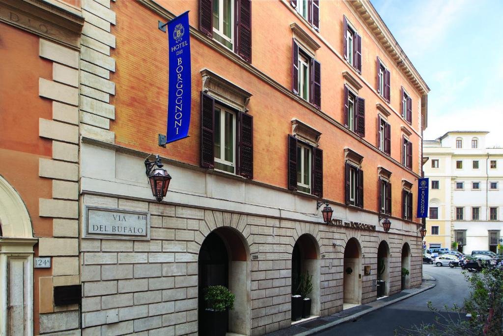 a building with a blue sign on the side of it at Hotel dei Borgognoni in Rome