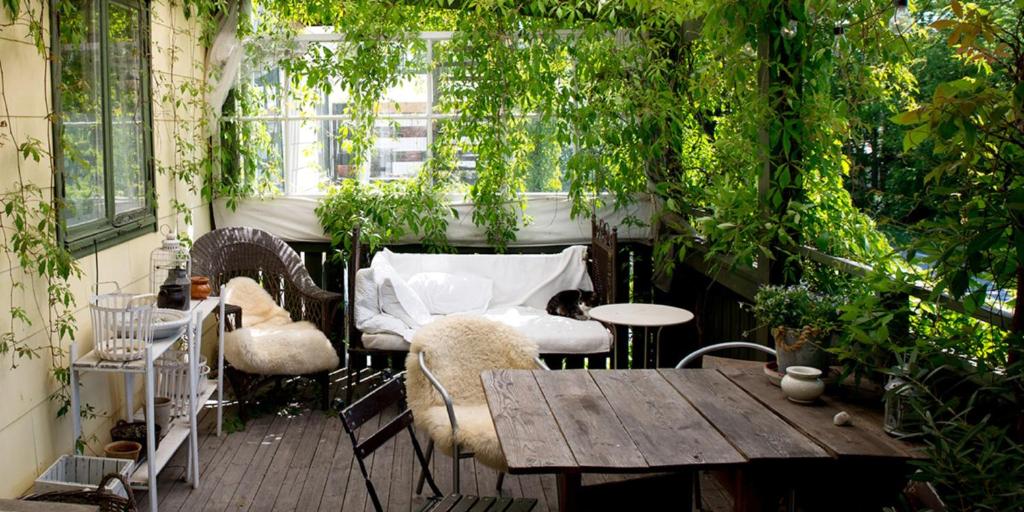 un patio con tavolo, sedie e piante di Kustnära Vandrarhem a Hamburgsund