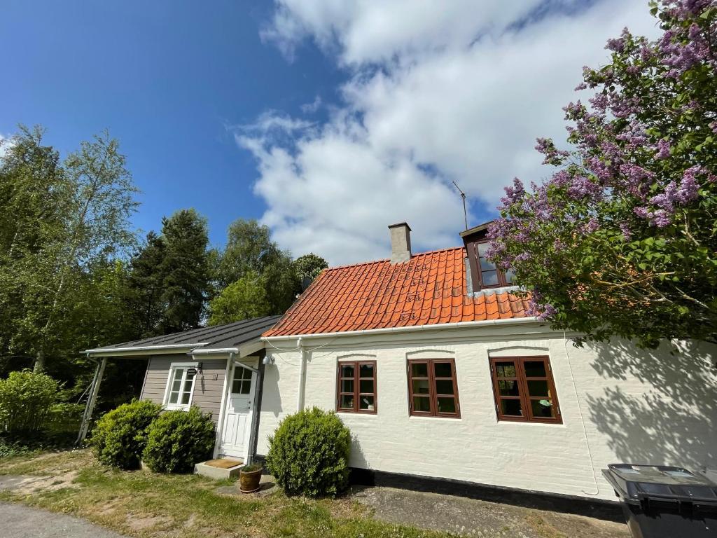 una casa blanca con techo naranja en A true nature pearl in idyllic surroundings but close to the city, en Holbæk