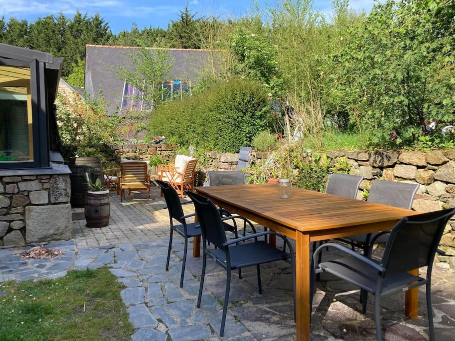 une table et des chaises en bois sur une terrasse dans l'établissement Maison avec jardin /proche plage, à Planguenoual