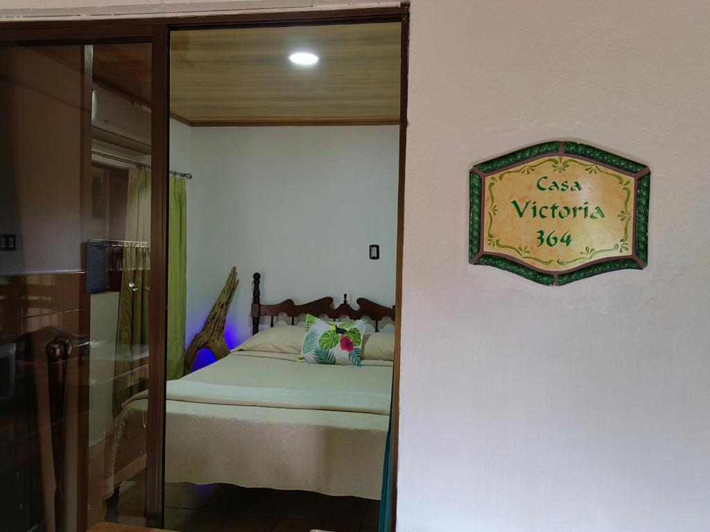 a bedroom with a bed with a sign on the wall at Casa Victoria in Puntarenas
