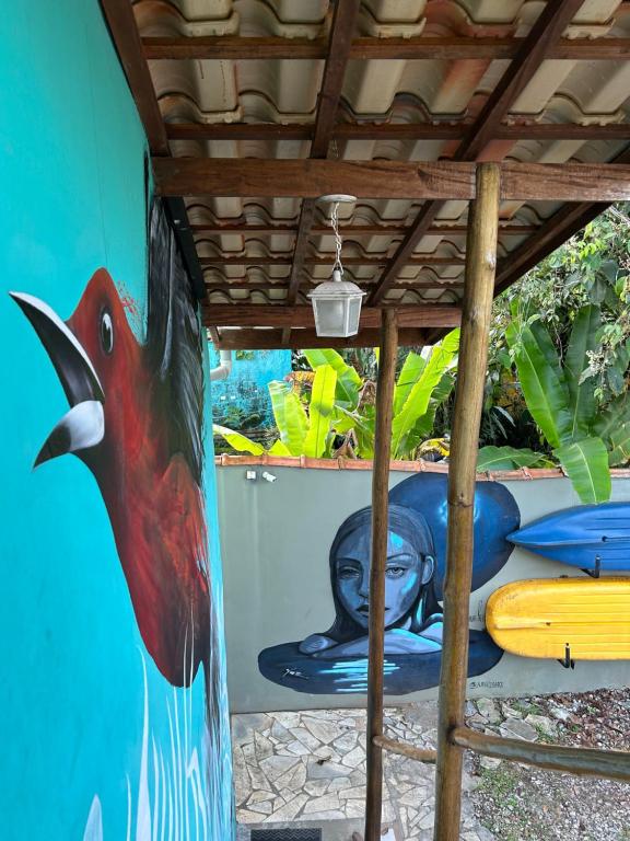 a wall with a painting of a dolphin and surfboards at Guest House Vida Vibra in Ubatuba