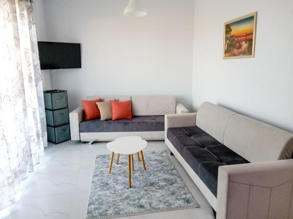 a living room with a couch and a table at Orik Apartament in Vlorë