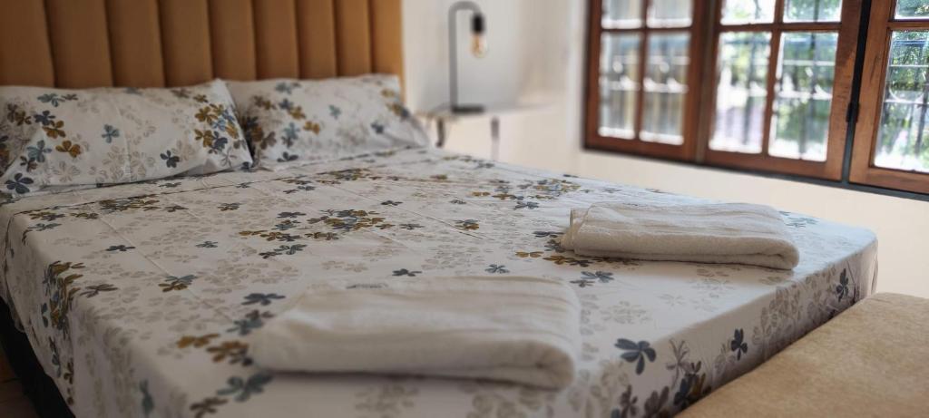 Una cama con toallas y dos almohadas. en Canciller House Godoy Cruz en Godoy Cruz