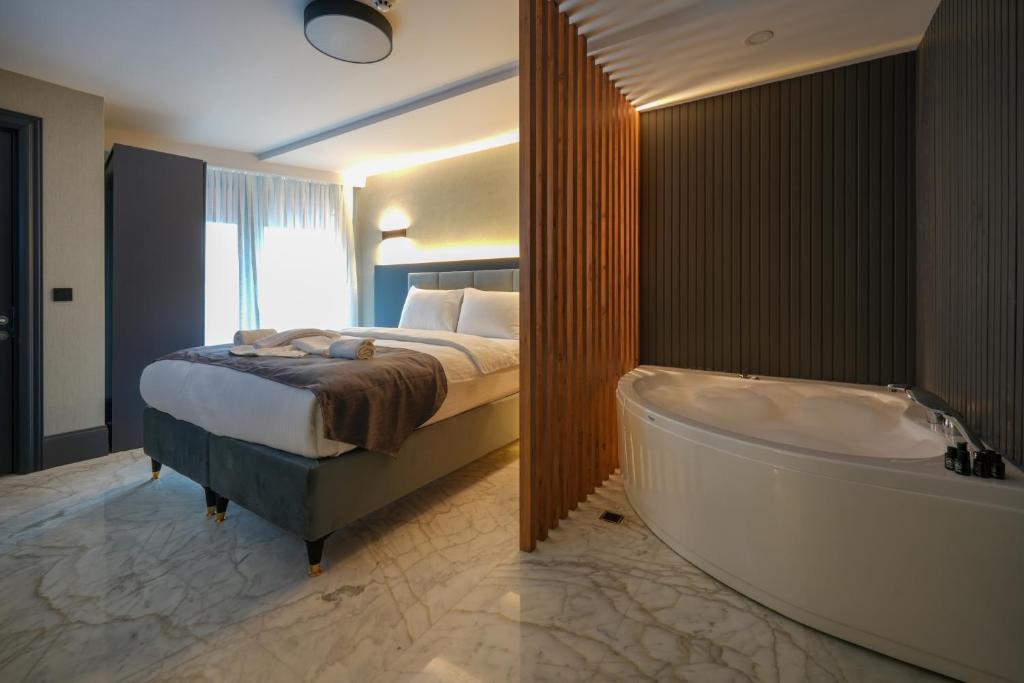 1 dormitorio con 1 cama y bañera en una habitación en Hotel Kurucesme Business en Estambul
