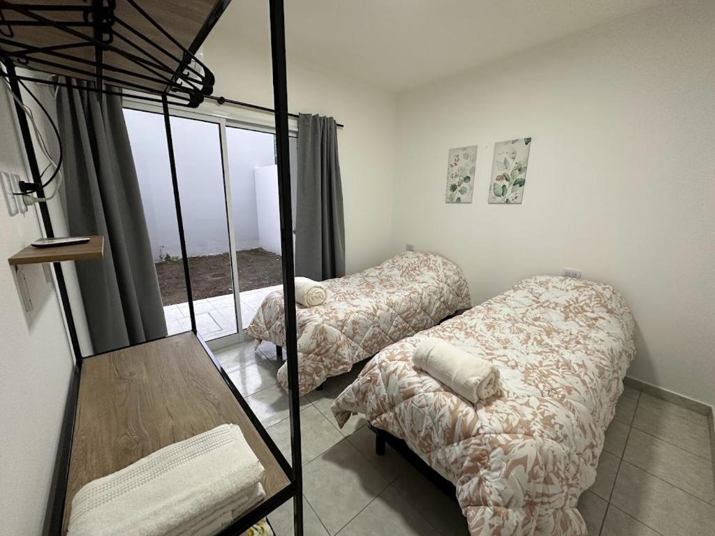 a bedroom with two beds and a mirror at DON SIMON Apart 2 - departamento nuevo in Esperanza