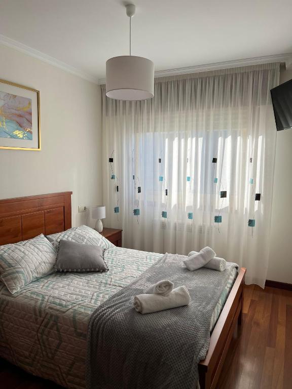 メリーデにあるApartamento Marichuのタオルが敷かれたベッドのある寝室