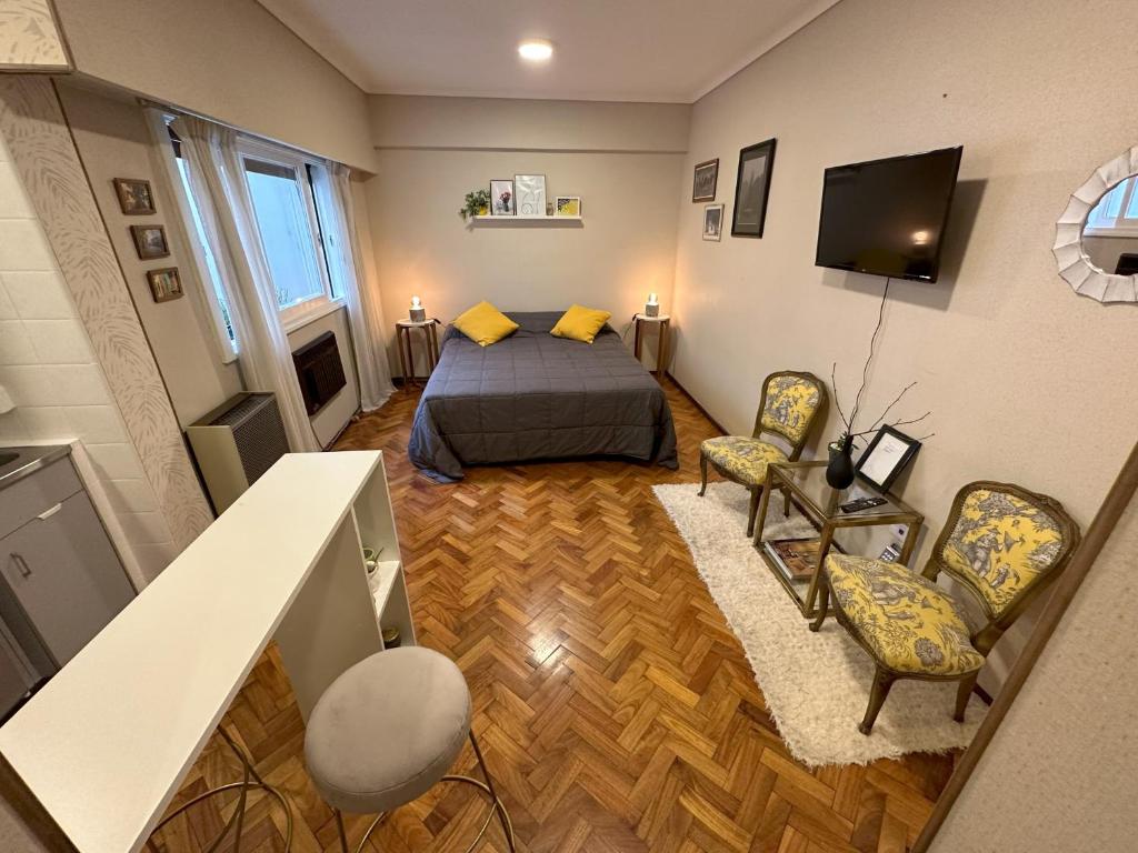 1 dormitorio con 1 cama, 2 sillas y TV en Guty en Buenos Aires