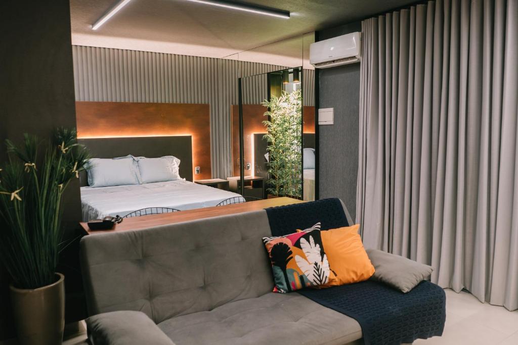 um quarto com uma cama e um sofá em Flat Bristol 911 em Goiânia