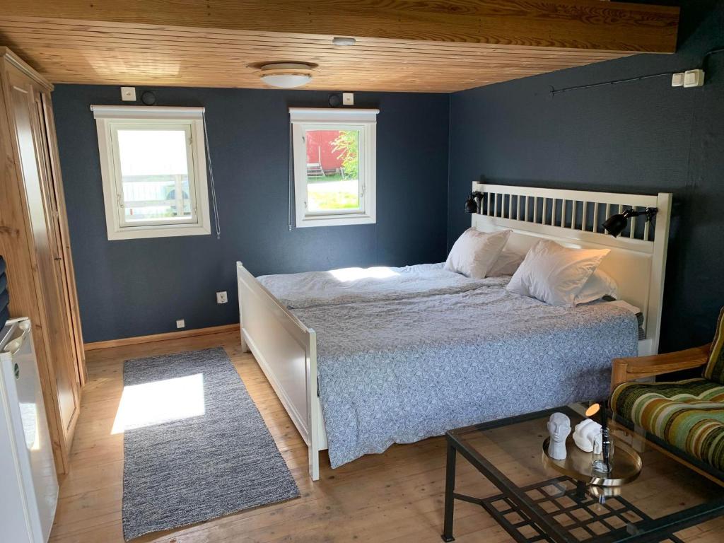 a bedroom with a bed with a blue wall at The Blue Cabin in Tyfta