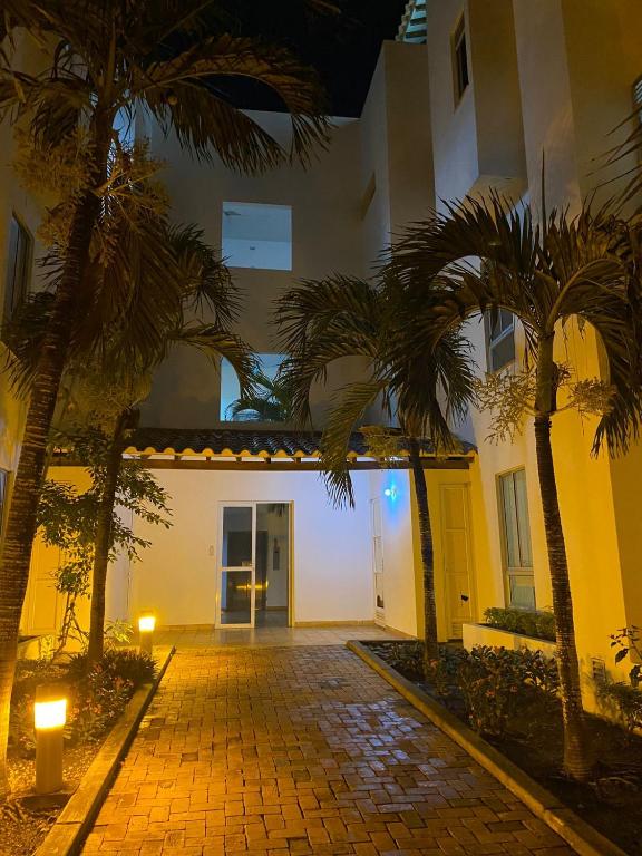 a courtyard with palm trees in front of a building at Laguna club zona norte - se renta con vehículo in Cartagena de Indias
