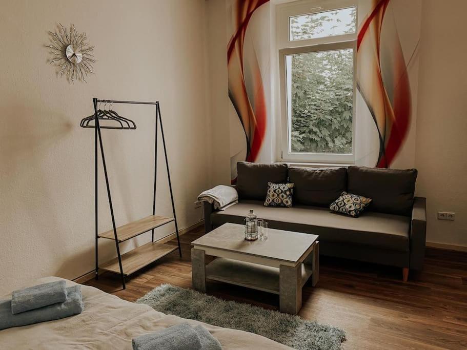 salon z kanapą i stołem w obiekcie Unser sonniges Apartment mit WLAN, Netflix, XBox w mieście Magdeburg