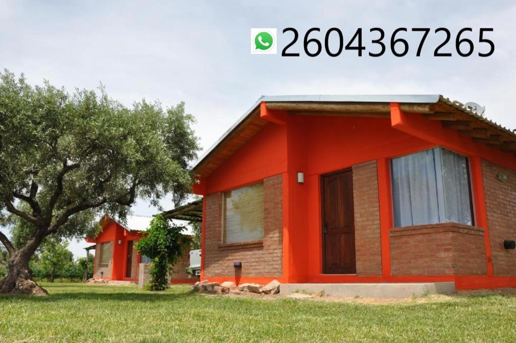 una casa con una naranja en un campo en Cabañas Los Viñedos en San Rafael