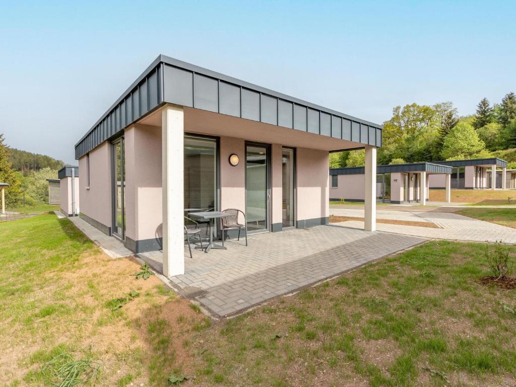 a small house with a patio in a yard at Eifel Countryside Comfort in Hallschlag