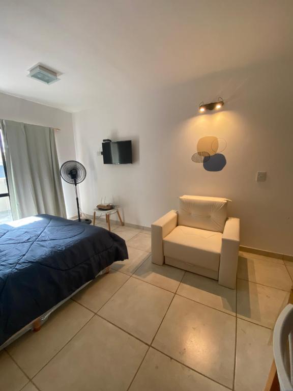 サンベルナルドにあるComplejo Aires 3のベッドと椅子とテレビのある寝室