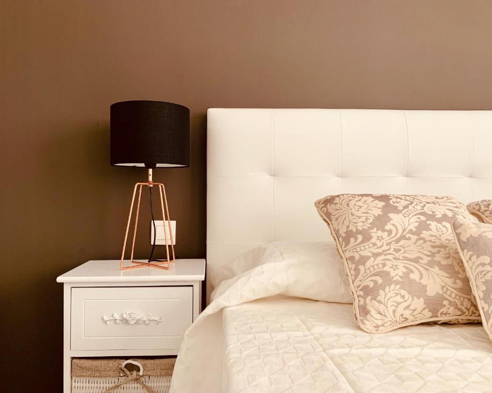 una cama blanca con una lámpara negra en una mesita de noche en A&F Comfort Modern House, en Vecindario