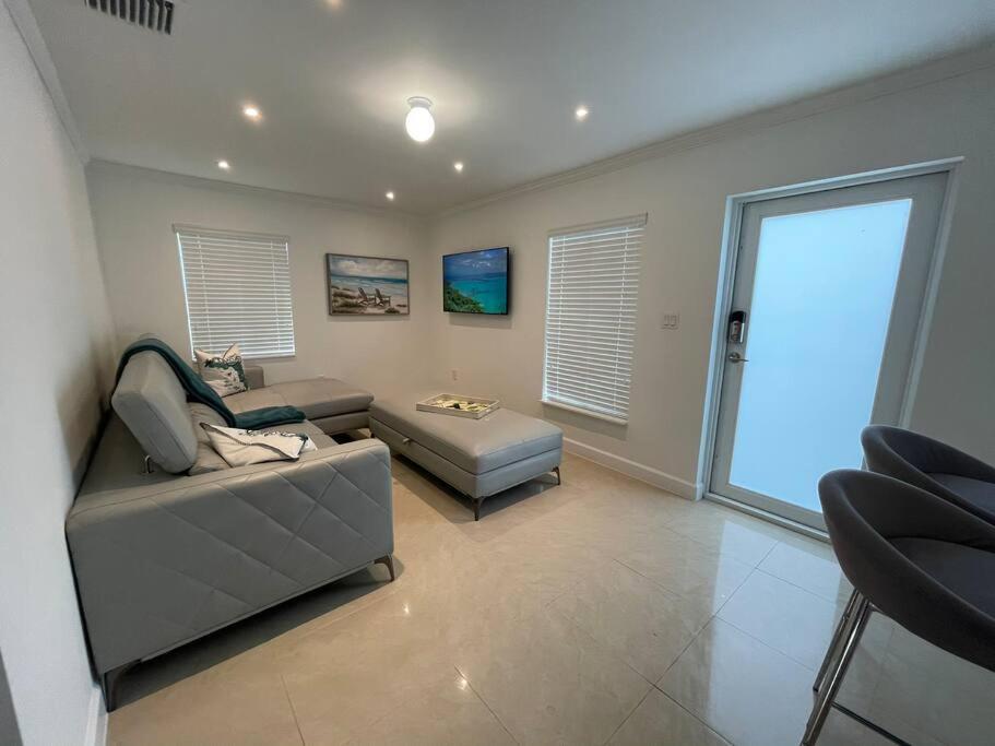 uma sala de estar com um sofá e uma mesa em Villa Capri Cottage in the heart of Miami em Miami