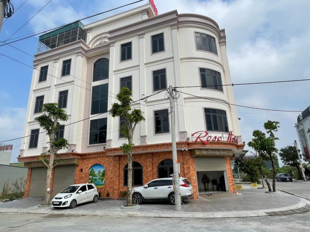 a white building with cars parked in front of it at Rose hotel 