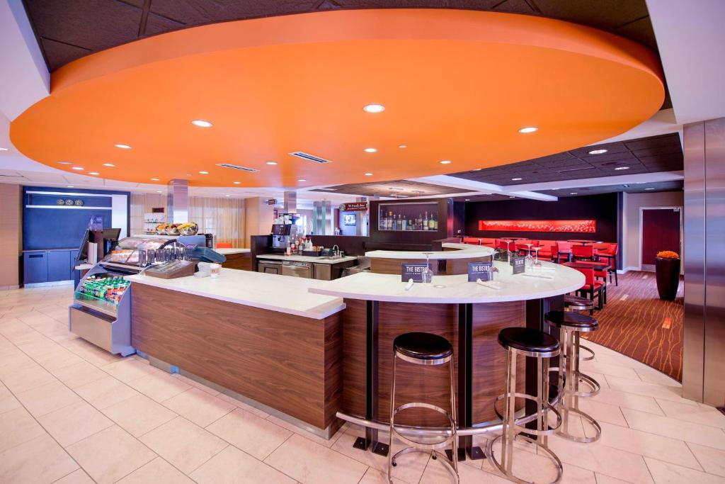 a restaurant with a bar with an orange ceiling at Courtyard Wausau in Wausau
